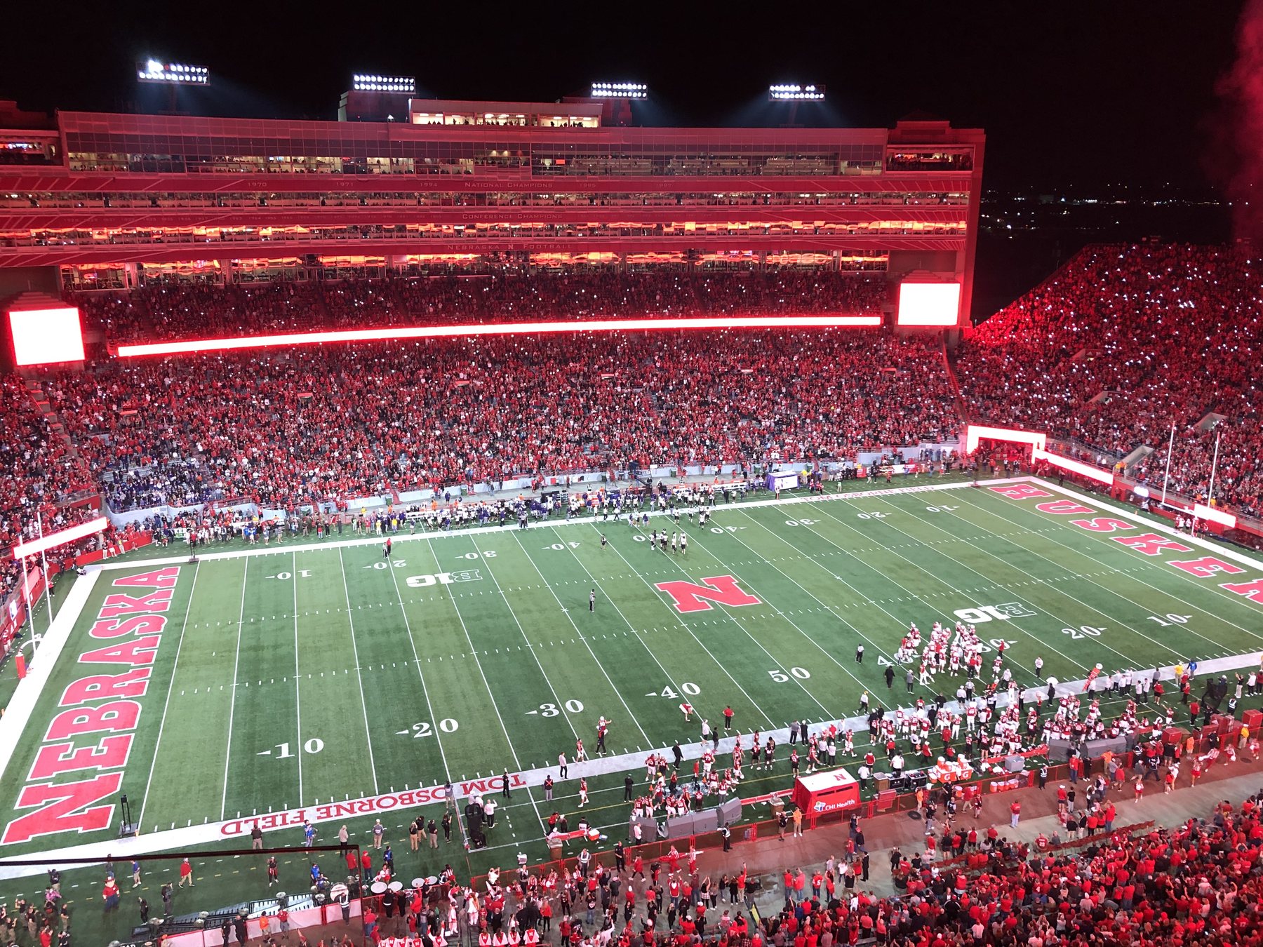 Memorial Stadium at night, filled with red, the N at midfield.